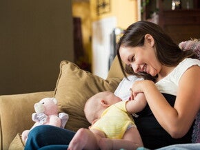 A mother breastfeeding her baby monitoring breast milk allergy.