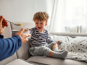 A fussy toddler refusing to eat during mealtime.