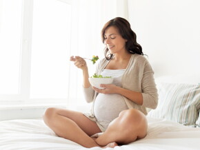 A woman eating some pregnancy healthy food.