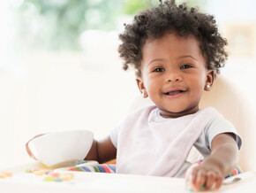 A child smiling during their teething symptoms