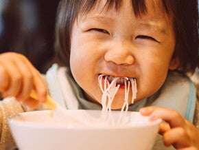 A woman and her child share one of the family meals for toddlers.