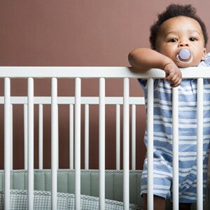 It's important to do some baby proofing strategies in your home. A Baby boy standing in cot