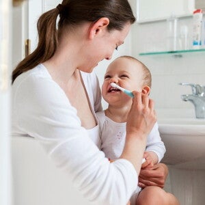 A mother taking care of her children’s dental care