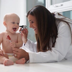 An ear infection is quite common in babies and infants A baby is being checked for an ear infection by a pediatrician.