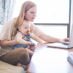 Breast pumps are very useful for modern mothers and their babies. A woman with his son researching breast pumps on her computer.