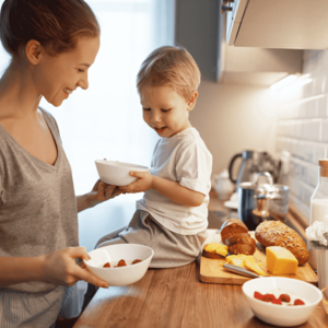 Get to know the benefits of eating together for the development of your kids. Mom and his toddler eating together.