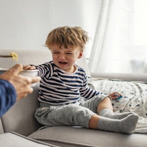 While your child is growing, he can become a picky eater A toddler being a picky eater and rejecting food from his parent.