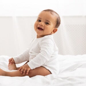 With time, your baby will be ready for potty training. A baby smiling after being in potty training