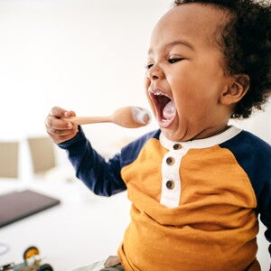 A Healthy Toddler Diet is essential for your child growth. A child eating yoghurt, part of a healthy toddler diet.