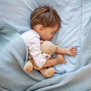 Learn more about how to deal with your toddler sleep problems. A child sleeping without any toddler sleep problems.