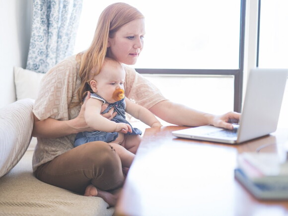 A woman with his son researching breast pumps on her computer.