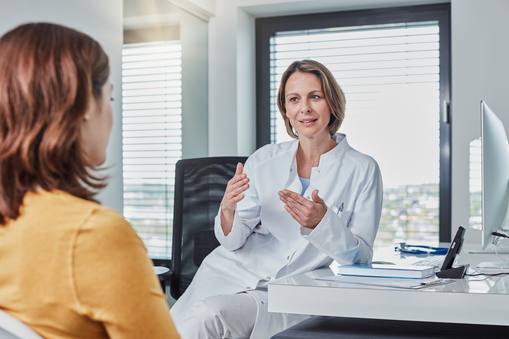It is important to attend health professionals to check your health during pregnancy. A physician talks to her patient during an antenatal care check.