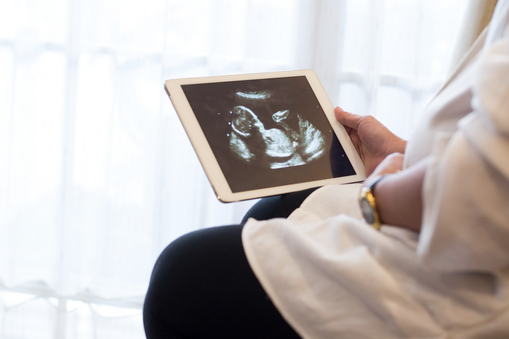 Antenatal care will teach you a lot about how to take care of your health. Pregnant woman watching ultrasound image on a digital tablet.