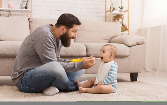 a father encouraging his baby's first words through communication during meals