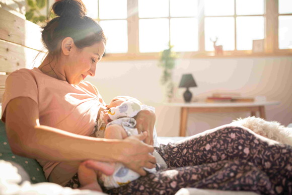 A woman feeding her child and enjoying the benefits of a beastfeeding diet