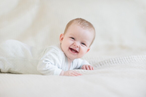 A baby smiling and showing his dental care.