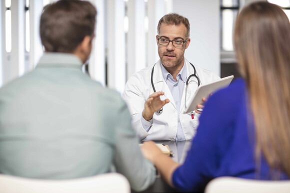 Doctor talking to a couple about the complications of C-sections.