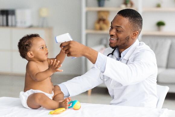 It’s important to consult your pediatrician in case of an ear infection. A baby getting his temperature checked by a doctor.
