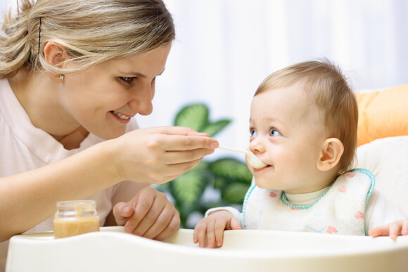 A mother feeding her child according to the toddler meal guide